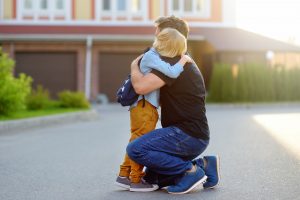 Little boy says goodbye and hugging to his father